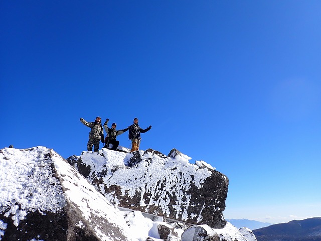 縞枯山展望台の大きな岩の上に立つ３人