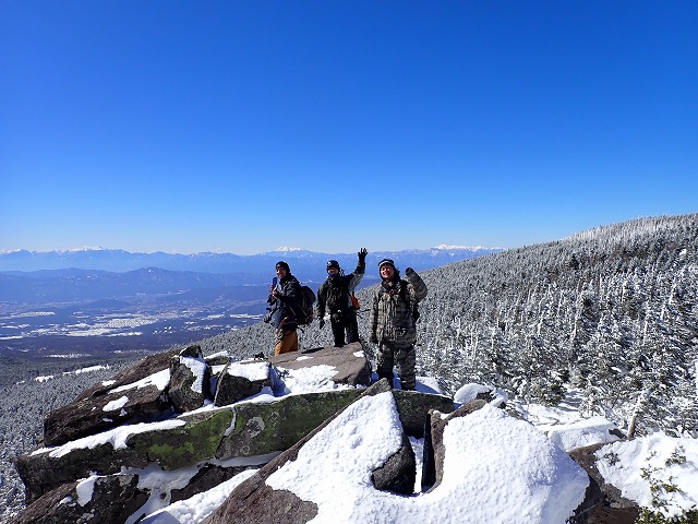 縞枯山展望台の大きな岩の上に立つ３人、乗鞍岳、御岳山、中央アルプスをバックに